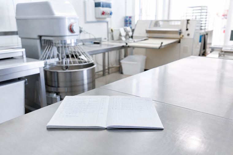 Porta a vetri con telaio in acciaio inox all'ingresso di un laboratorio alimentare.